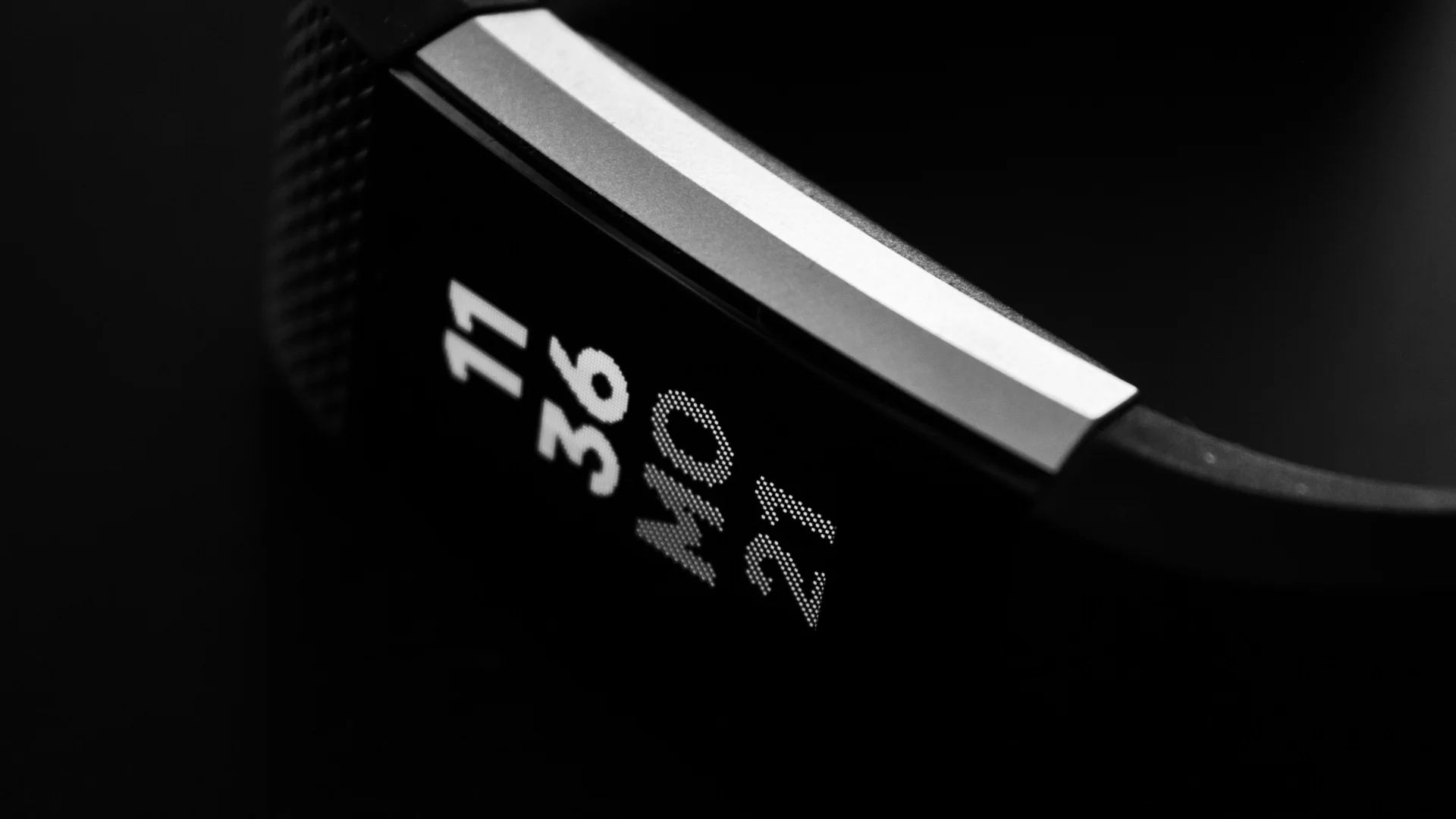 Pulsera de actividad negra mostrando la hora y la fecha en su pantalla